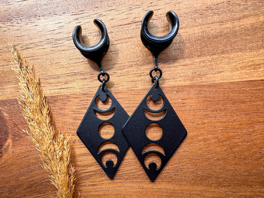 Black Lunar Obsession dangling plug earrings featuring celestial crescent moon designs with a gothic-inspired style for stretched ears.