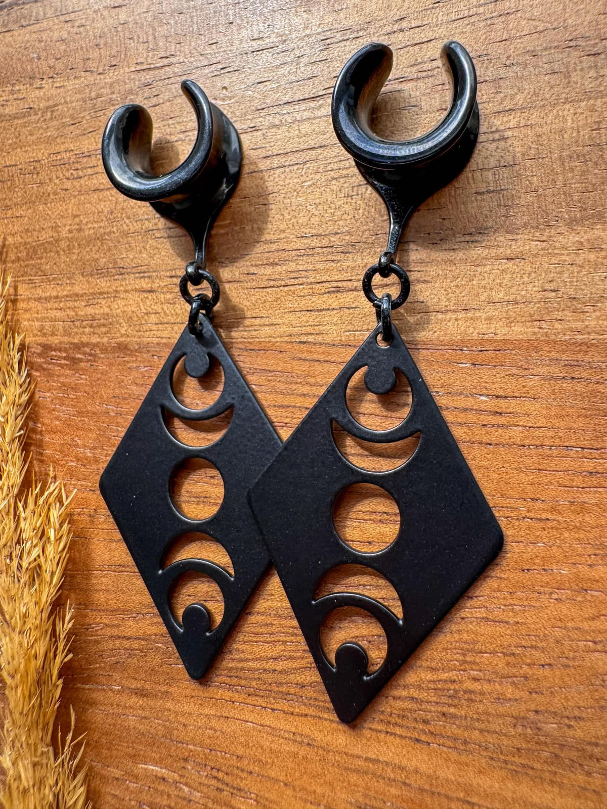 Black Lunar Obsession dangling plug earrings featuring celestial crescent moon designs with a gothic-inspired style for stretched ears.