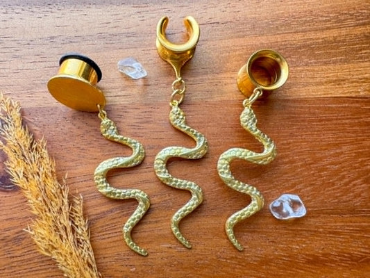 Brass snake plug earrings with detailed dangling serpent charms for stretched ears.