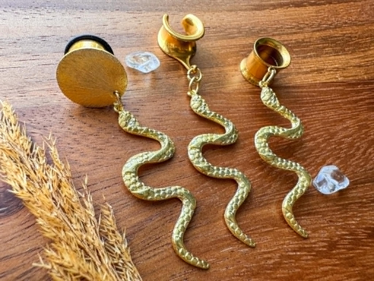 Brass snake plug earrings with detailed dangling serpent charms for stretched ears.