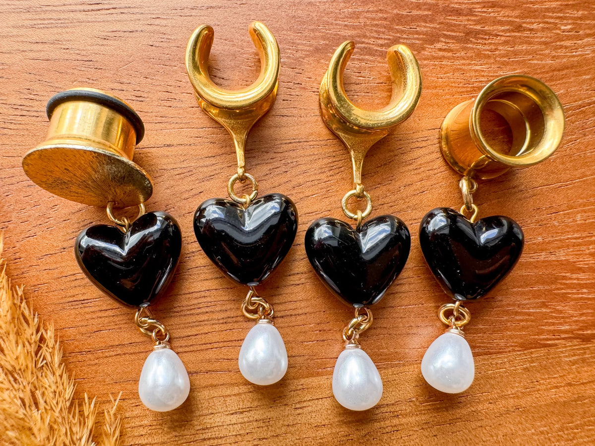 Gold black heart plug earrings with glossy heart charms and dangling white faux pearls for stretched ears.