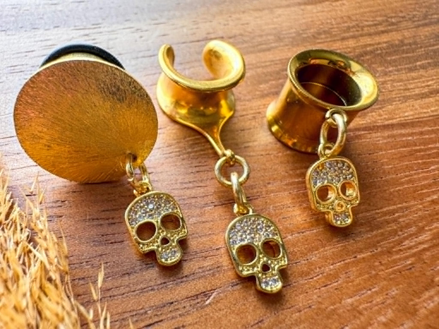 Gold mini skull plug earrings with sparkling zircon accents for stretched ears.