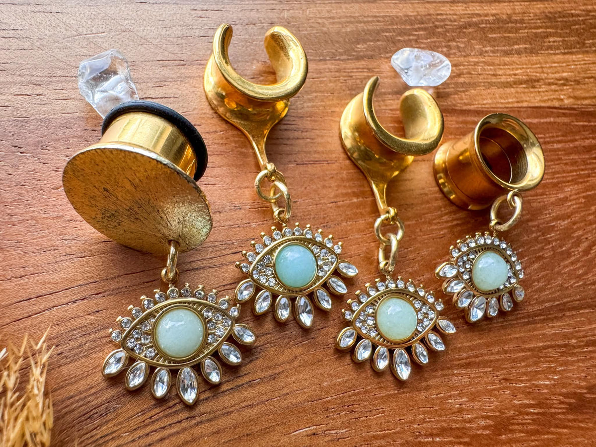 Gold Oracle's Eye plug earrings with detailed mystical eye inspired dangle charms for stretched ears.