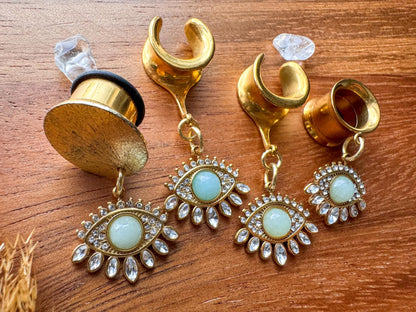 Gold Oracle's Eye plug earrings with detailed mystical eye inspired dangle charms for stretched ears.