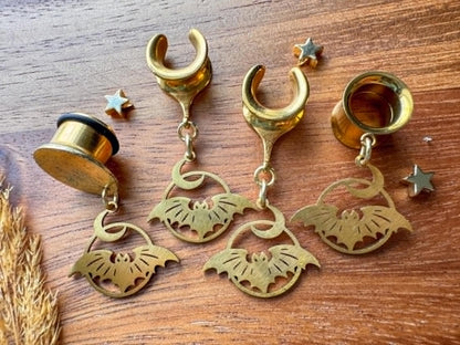 Gold stainless steel bat and crescent moon plug earrings with dangling celestial charms for stretched ears.
