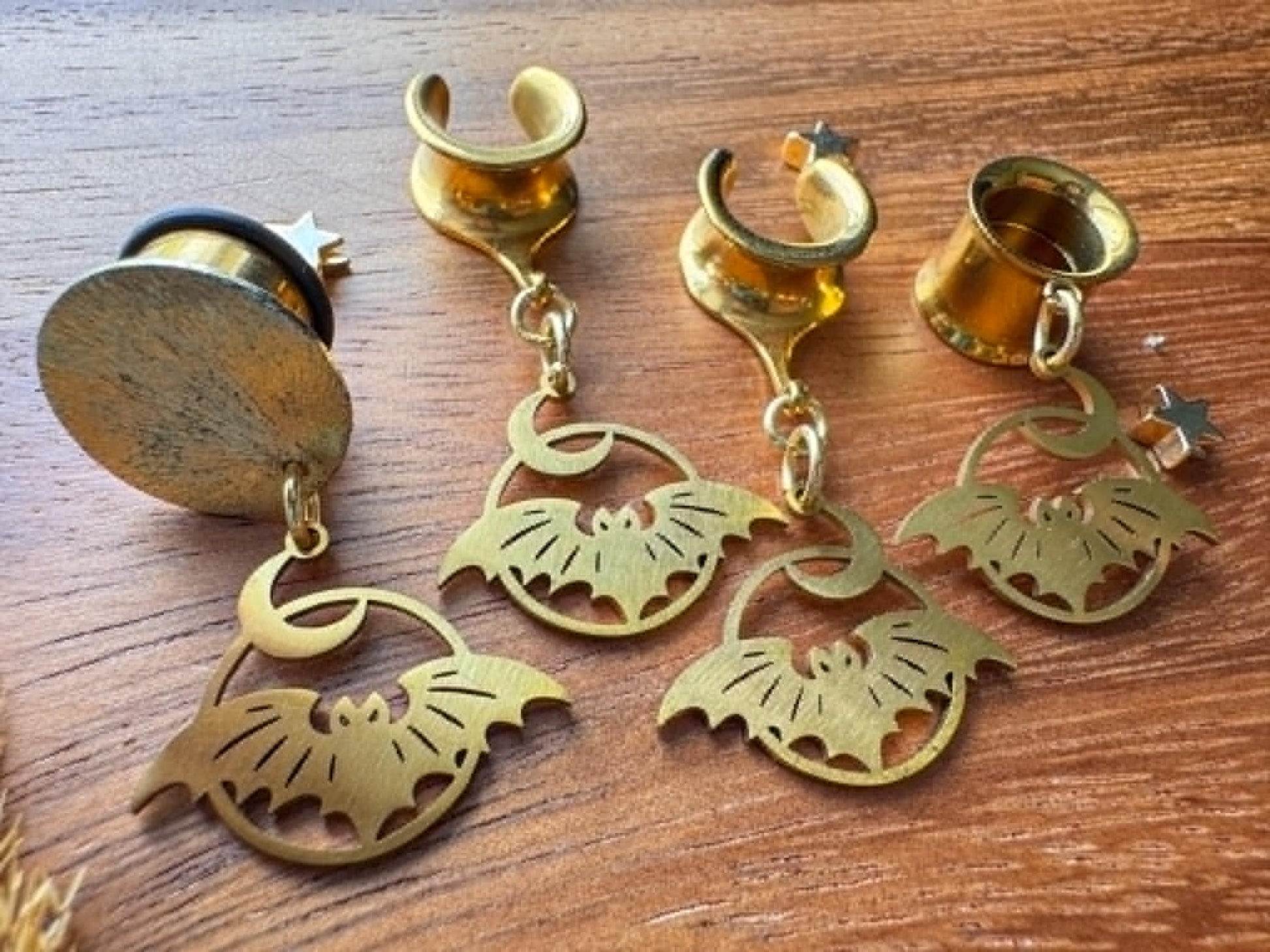 Gold stainless steel bat and crescent moon plug earrings with dangling celestial charms for stretched ears.