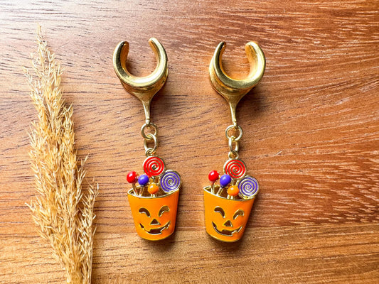 Gold Halloween treat basket plug earrings with dangling candy basket charms for stretched ears.