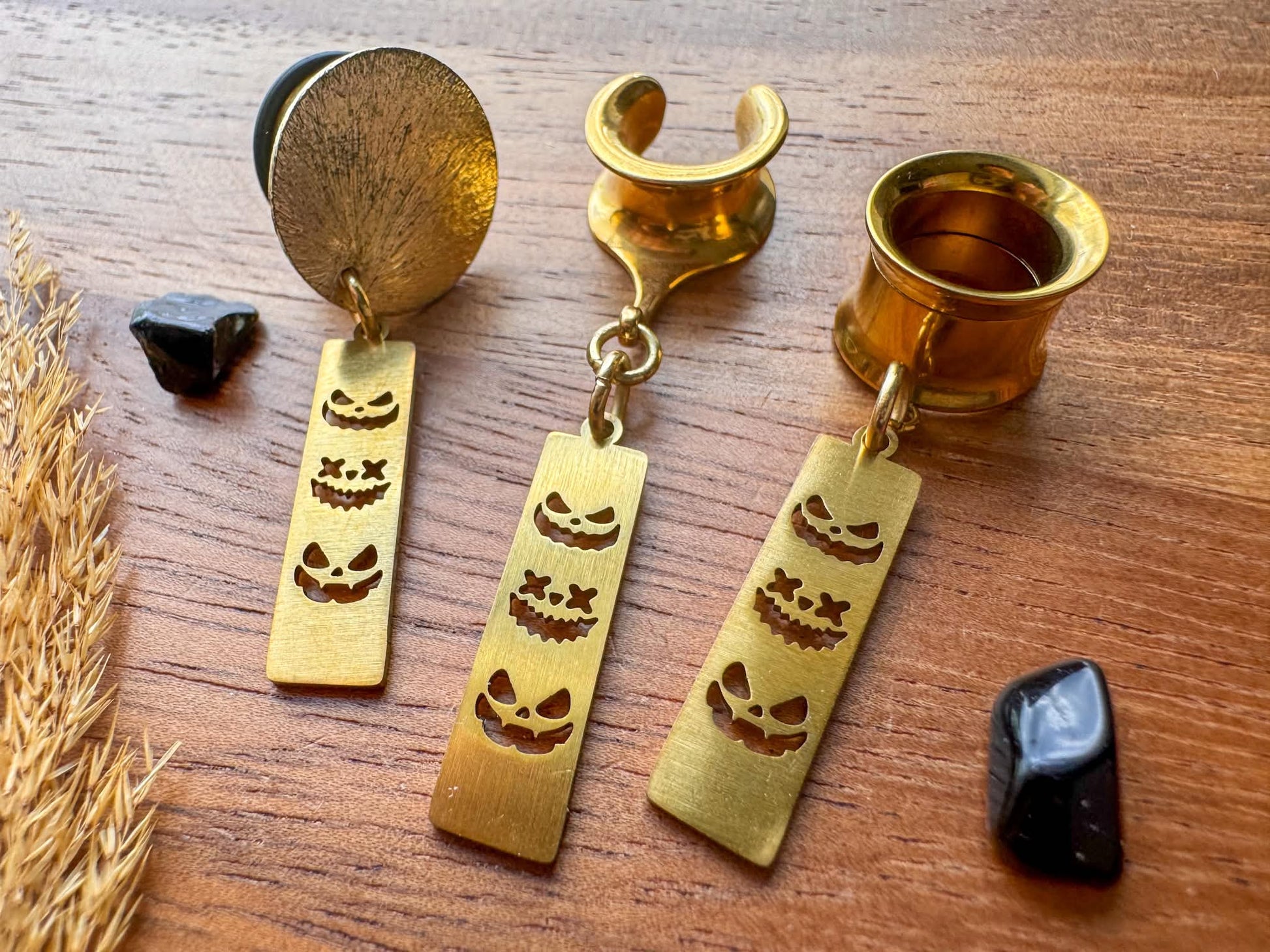 Gold trio jack o' lantern plug earrings with three dangling pumpkin faces for stretched ears.