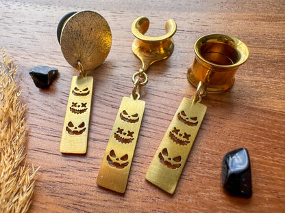 Gold trio jack o' lantern plug earrings with three dangling pumpkin faces for stretched ears.