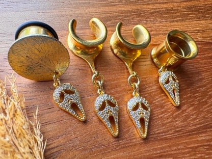 Gold saddle earrings with zircon Halloween masquerade mask charms for stretched ears.