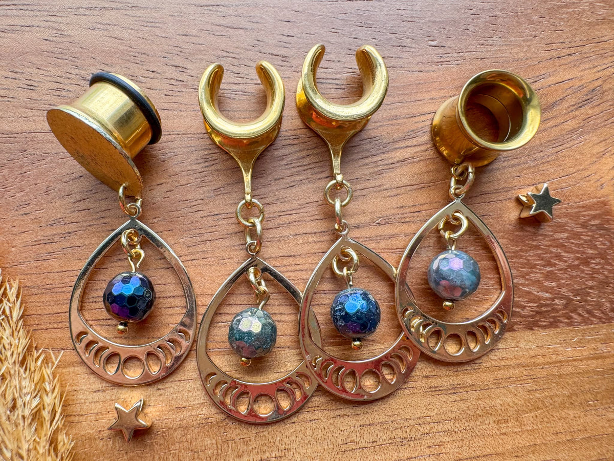 Gold iridescent teardrop plug earrings with faceted multicolor beads and intricate openwork frames for stretched ears.