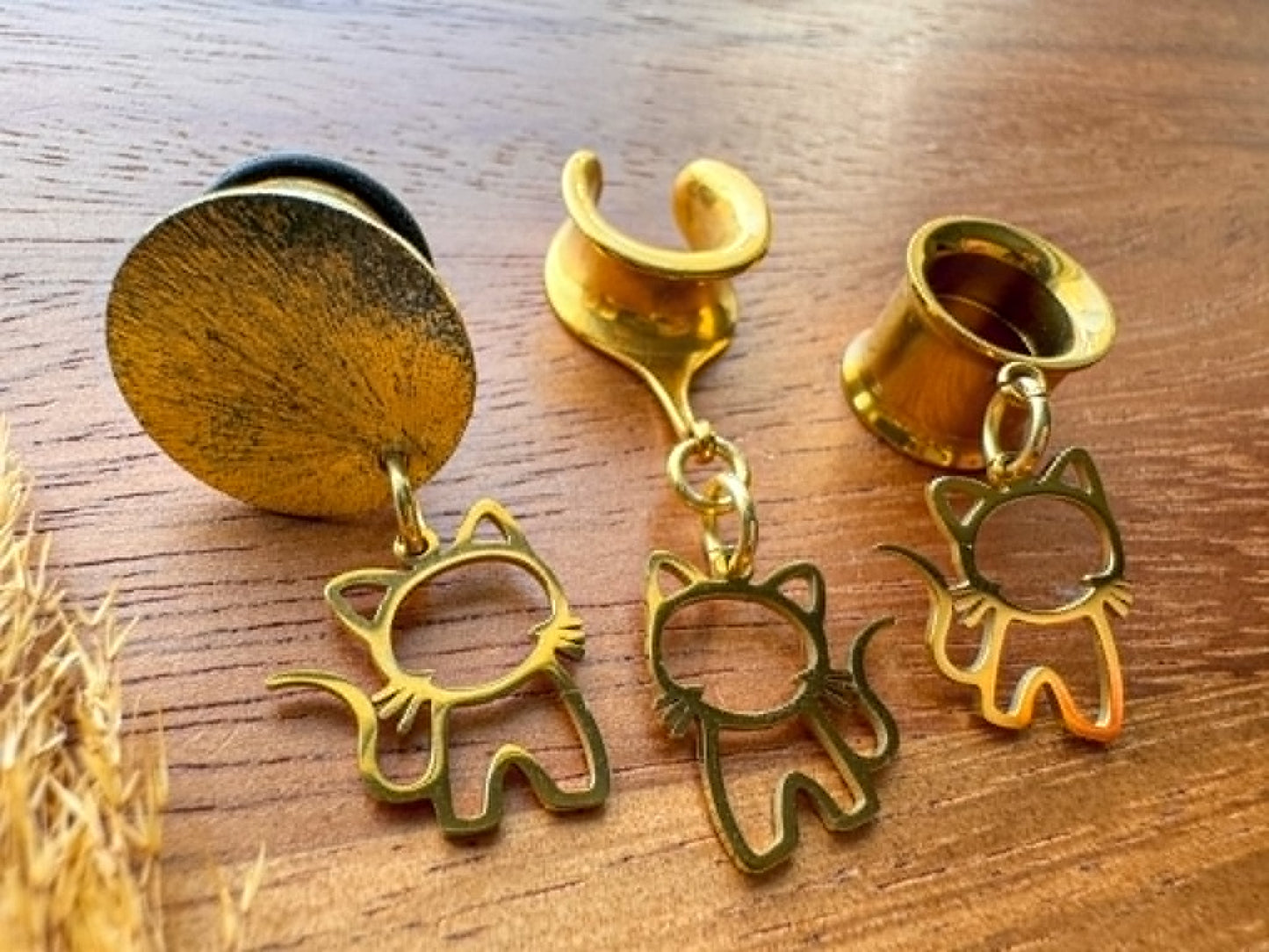 Golden stainless steel cat plug earrings with dangling cat charms for stretched ears.