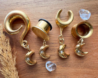 Mini gold crescent moon plug earrings with small celestial dangle charms for stretched ears.