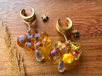 Orange and gold iridescent raincloud plug earrings with shimmering dangling details for stretched ears.