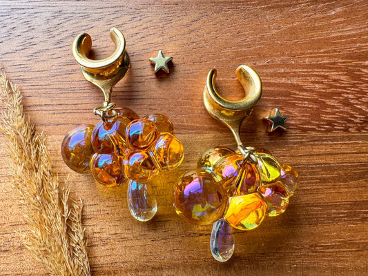 Orange and gold iridescent raincloud plug earrings with shimmering dangling details for stretched ears.