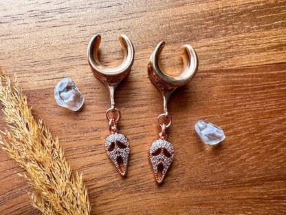 Rose gold Halloween mask plug earrings with sparkling masquerade style charms for stretched ears.