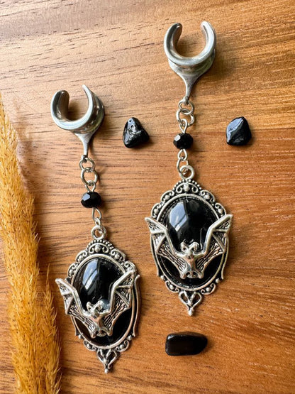 Silver and black bat crest plug earrings with gothic bat dangles for stretched ears.