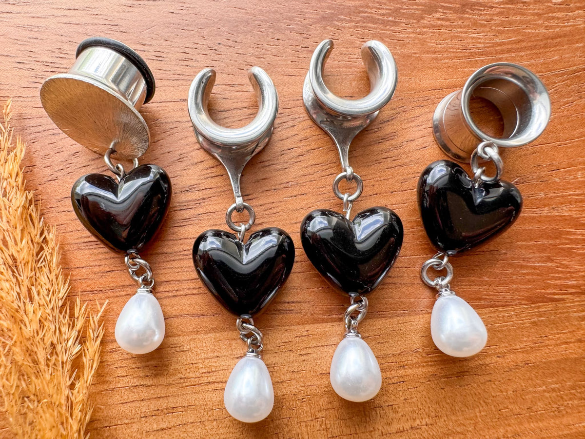 Silver black heart plug earrings with glossy heart charms and dangling white faux pearls for stretched ears.