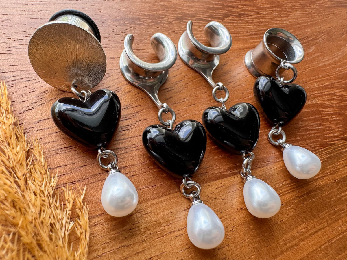 Silver black heart plug earrings with glossy heart charms and dangling white faux pearls for stretched ears.