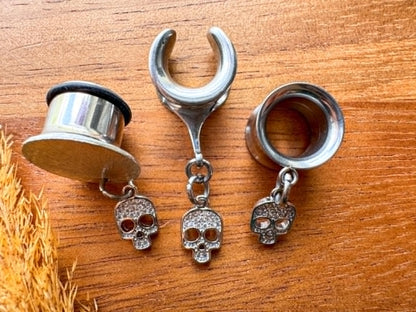 Silver mini skull plug earrings with sparkling zircon accents for stretched ears.