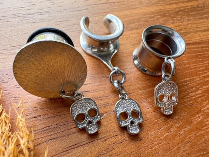 Silver mini skull plug earrings with sparkling zircon accents for stretched ears.