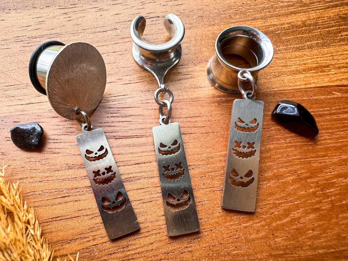 Silver trio jack o' lantern plug earrings with three face dangling pumpkin charms for stretched ears.