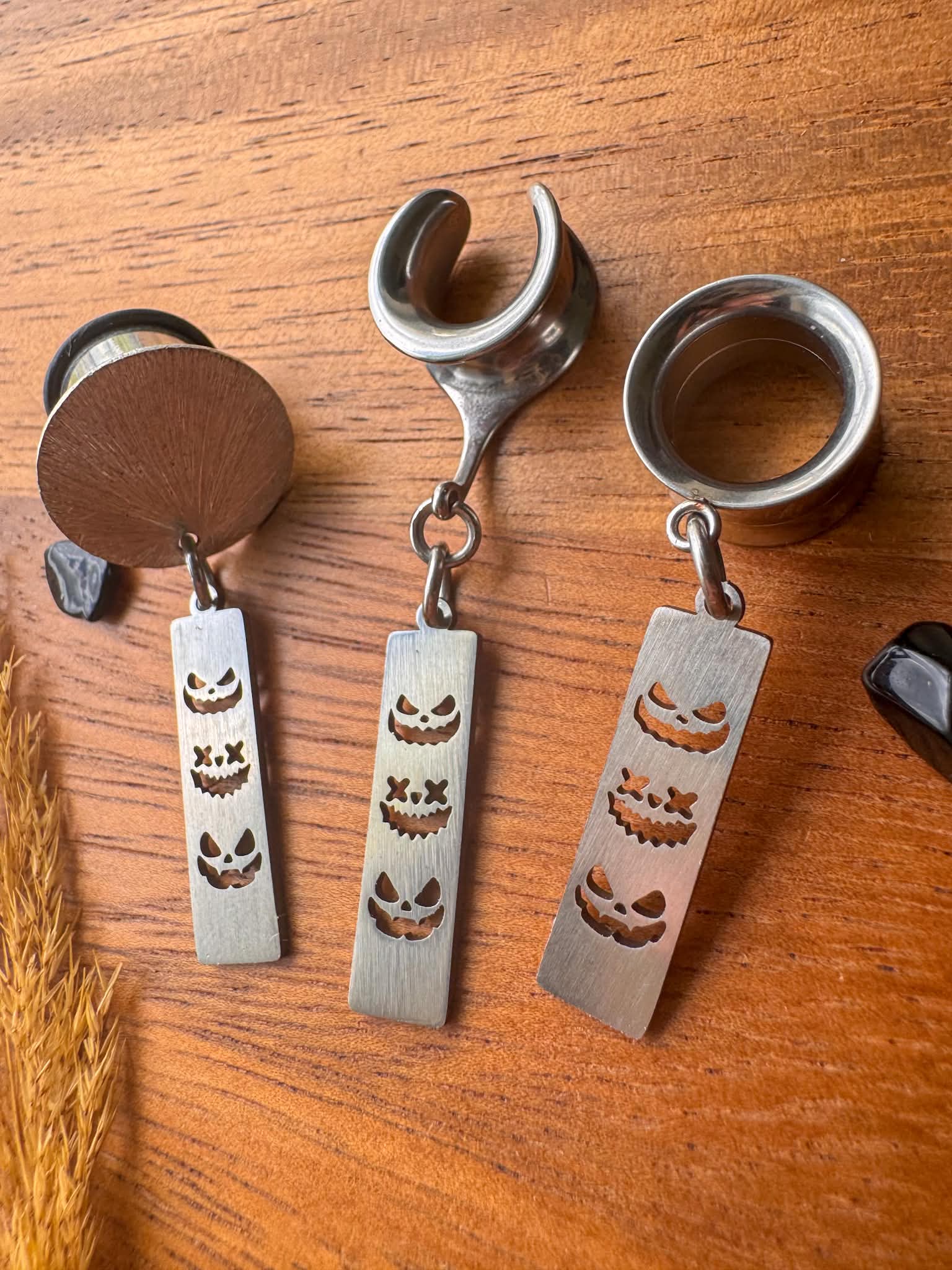 Silver trio jack o' lantern plug earrings with three face dangling pumpkin charms for stretched ears.