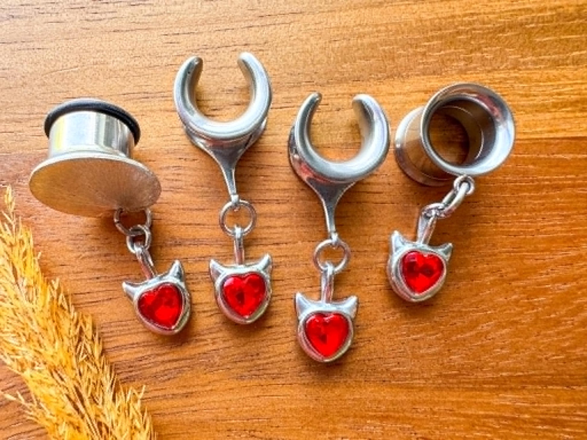 Silver and red devil heart plug earrings with dangling heart charms for stretched ears.