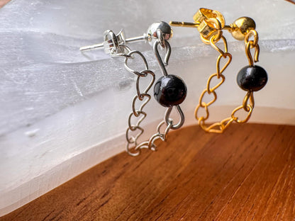 Silver or gold chain ball post earrings with dangling chains and black onyx details.