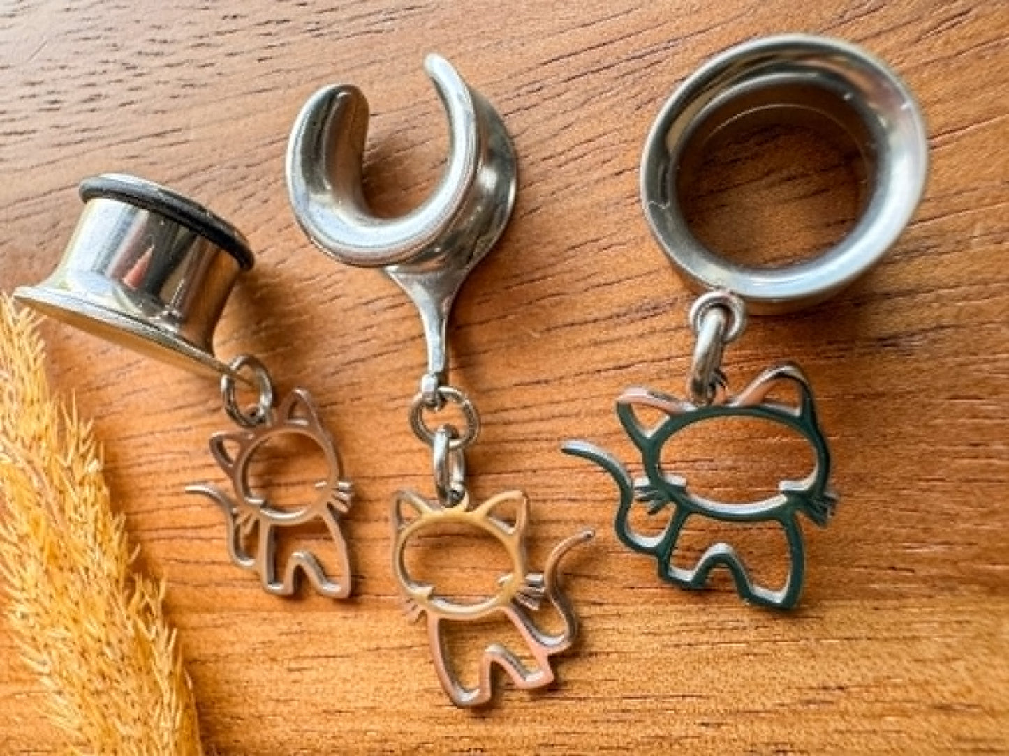 Stainless steel cat plug earrings with dangling cat charms for stretched ears.