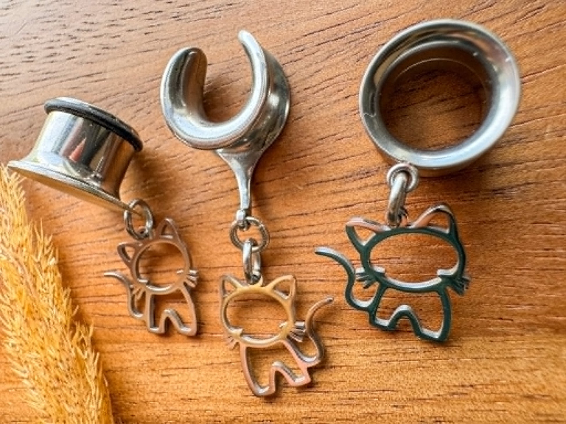 Stainless steel cat plug earrings with dangling cat charms for stretched ears.