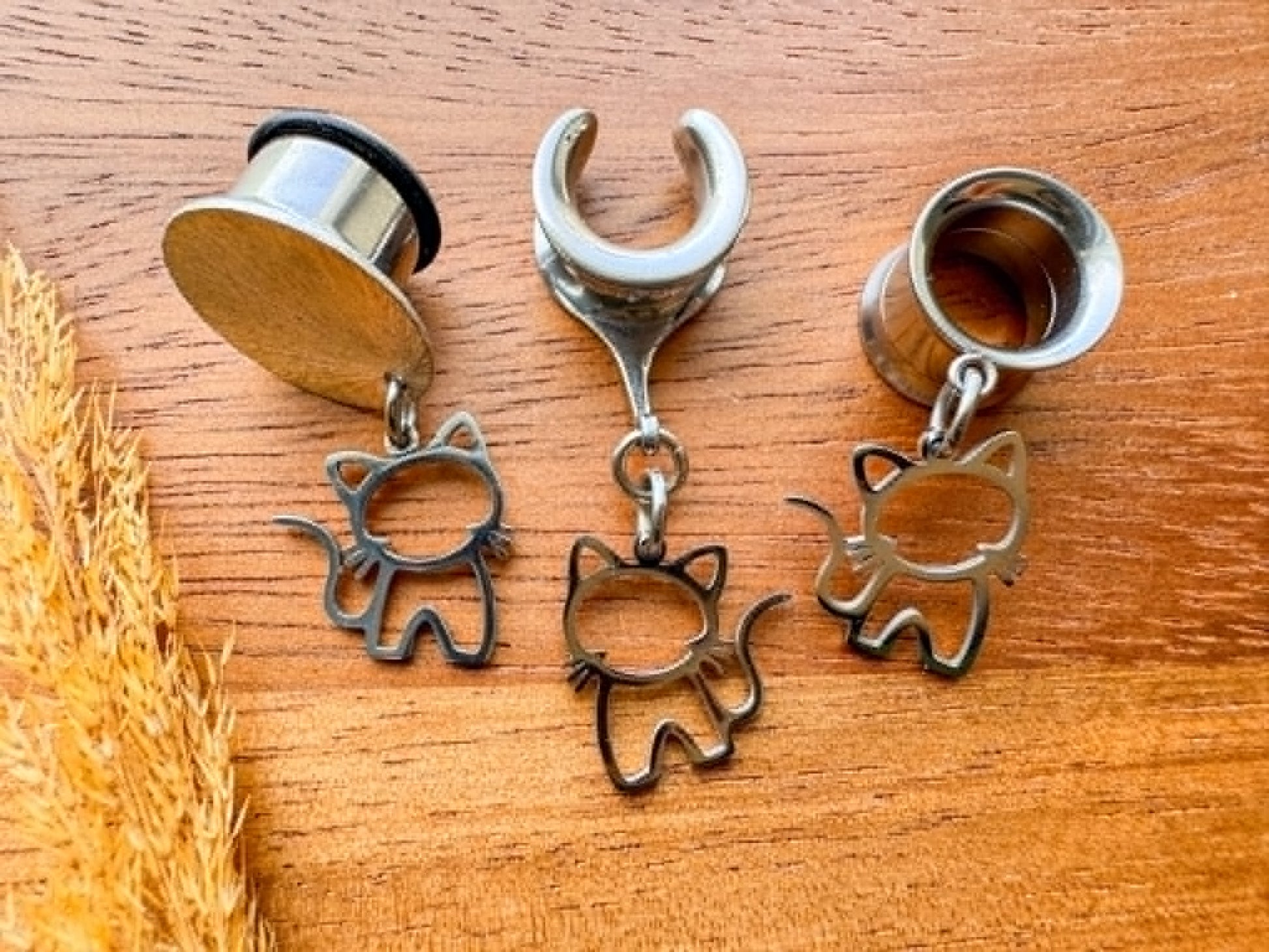 Stainless steel cat plug earrings with dangling cat charms for stretched ears.