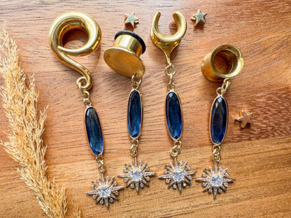 Gold plug earrings with deep blue faceted jewels and sparkling celestial starburst dangles for stretched ears.