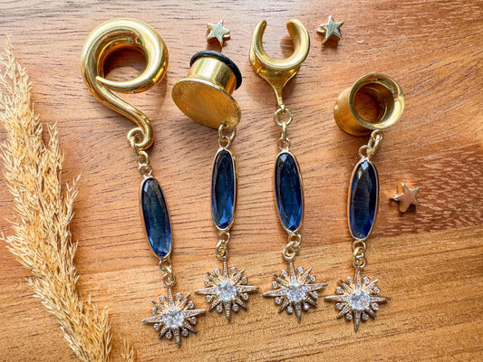 Gold plug earrings with deep blue faceted jewels and sparkling celestial starburst dangles for stretched ears.