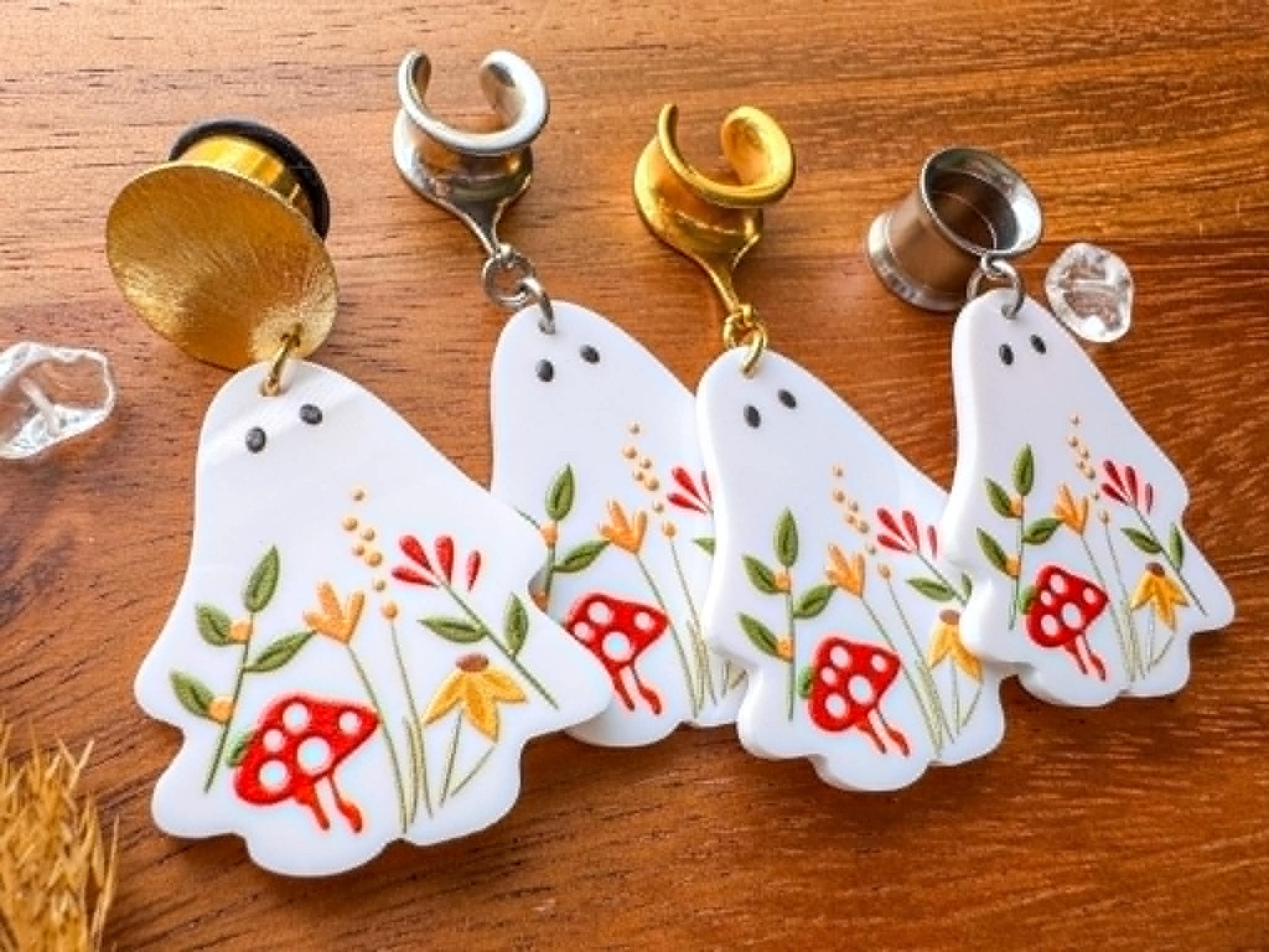 White garden ghost plug earrings with whimsical floral details and dangling ghost charms for stretched ears.